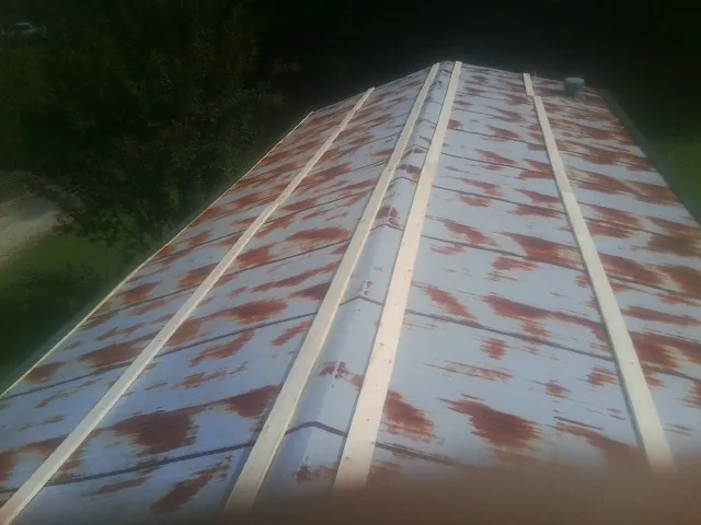 Rusted metal roof panels with new wood purlins before replacement — Storm Damage Roof Repair in Flossmoor by Roofing Brothers