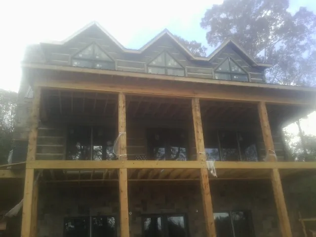 Dormers and porch framing on a large log home under construction — Roof Coating work by our crew in Flossmoor