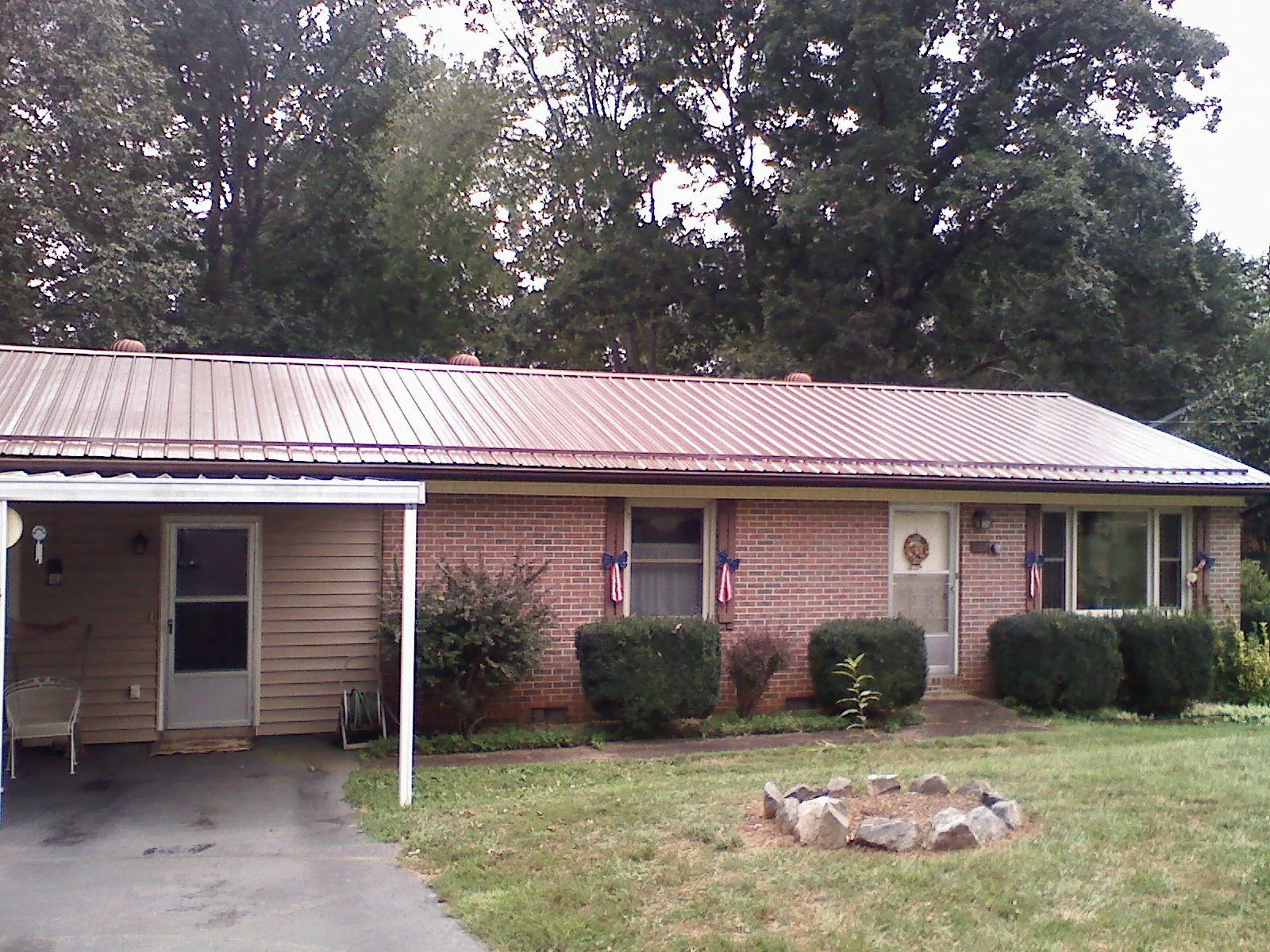 Bronze metal roof and carport on a brick ranch home — Roof Repair work by our crew in Flossmoor